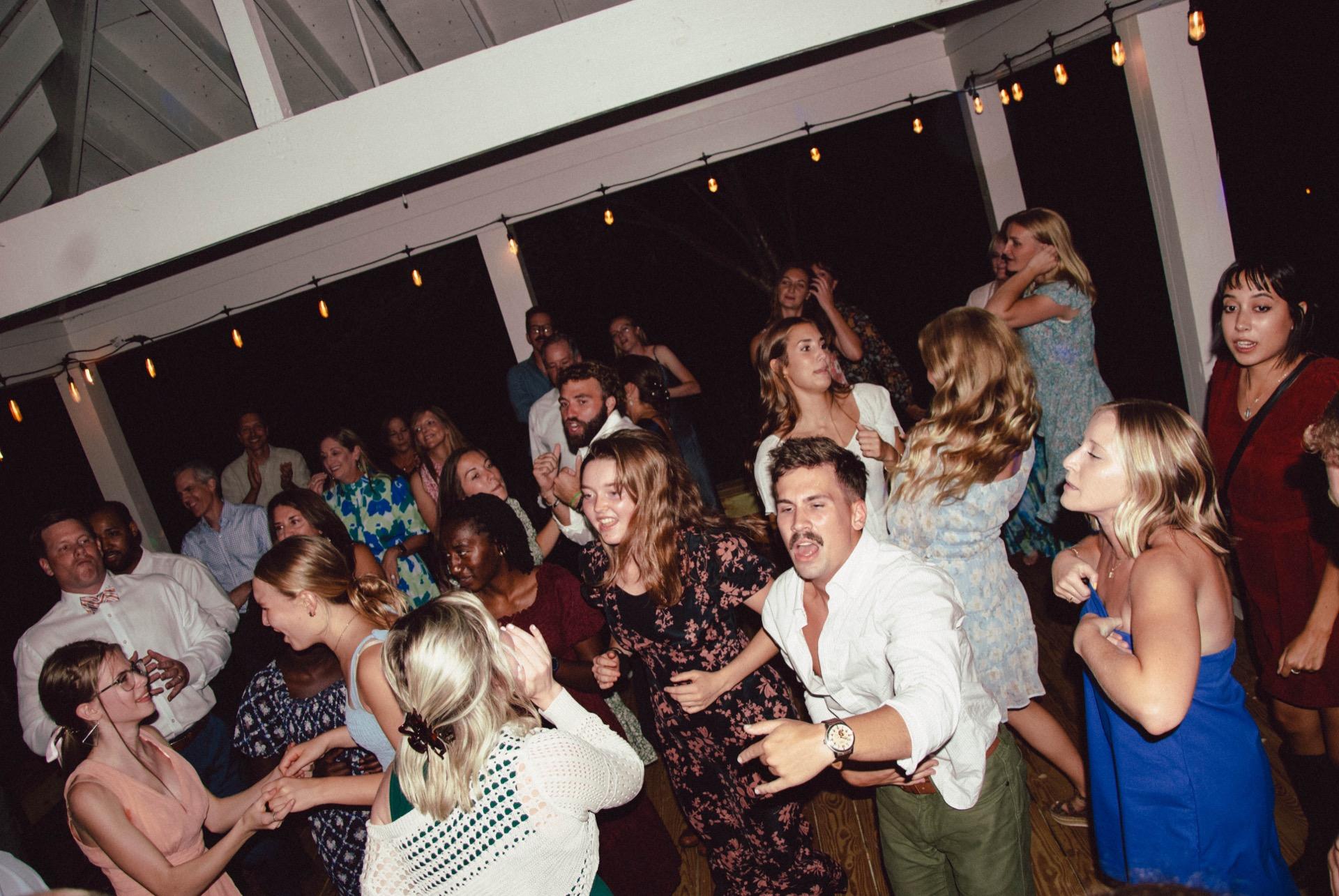 Guests dancing at a night-time wedding reception