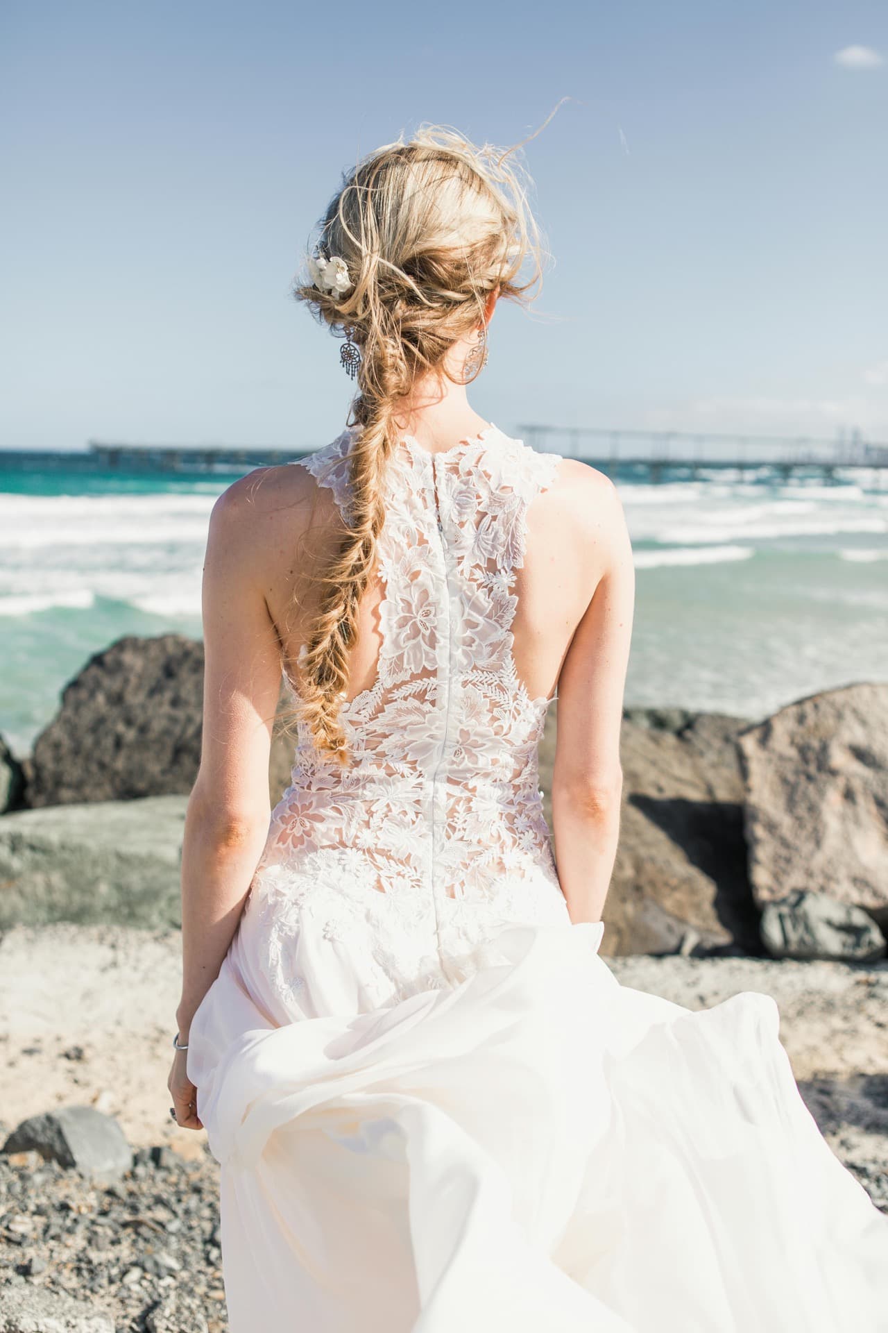 Bride in a white lace slip dress smiling in a sunlit park