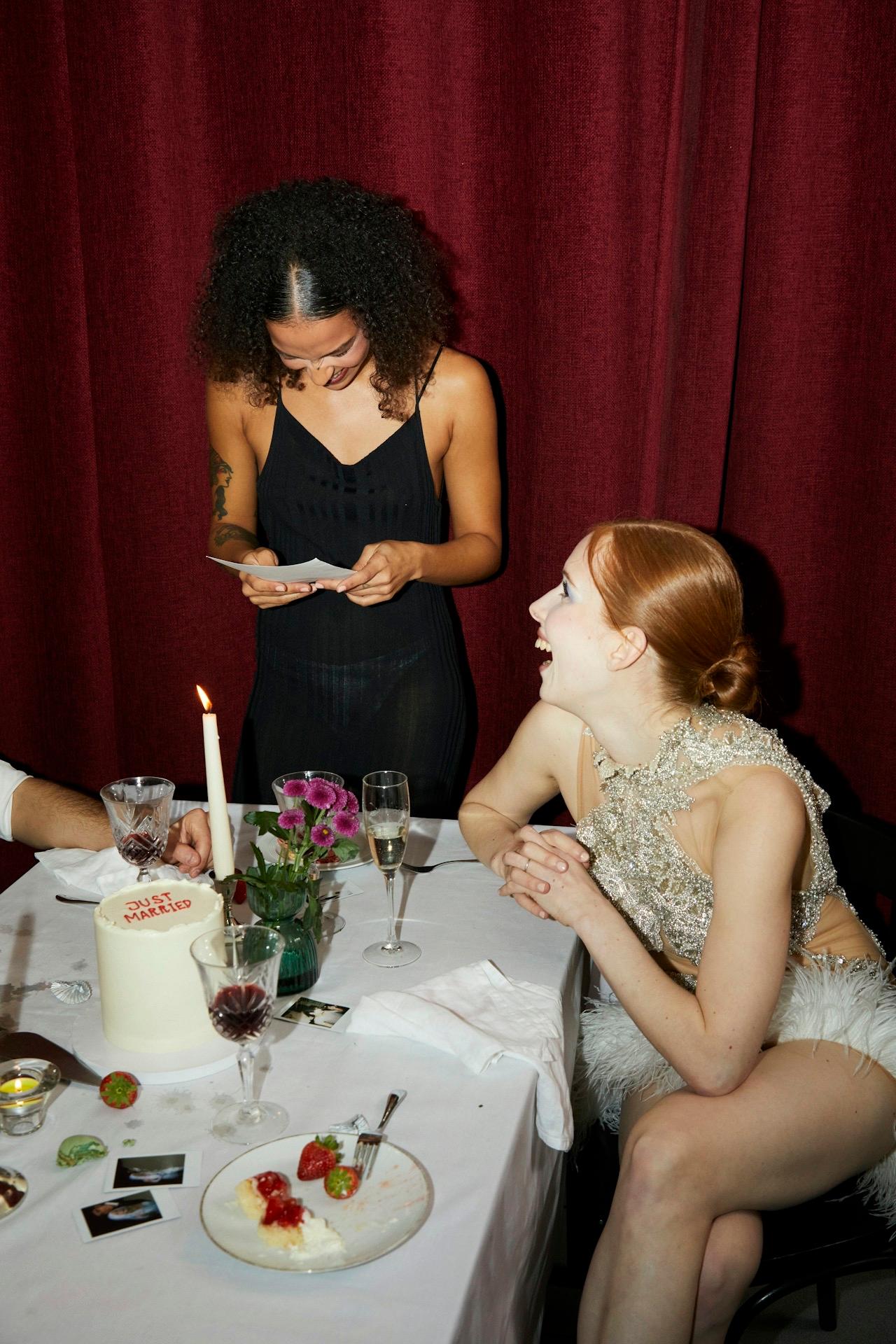 Newlyweds laughing at a candlelit reception table