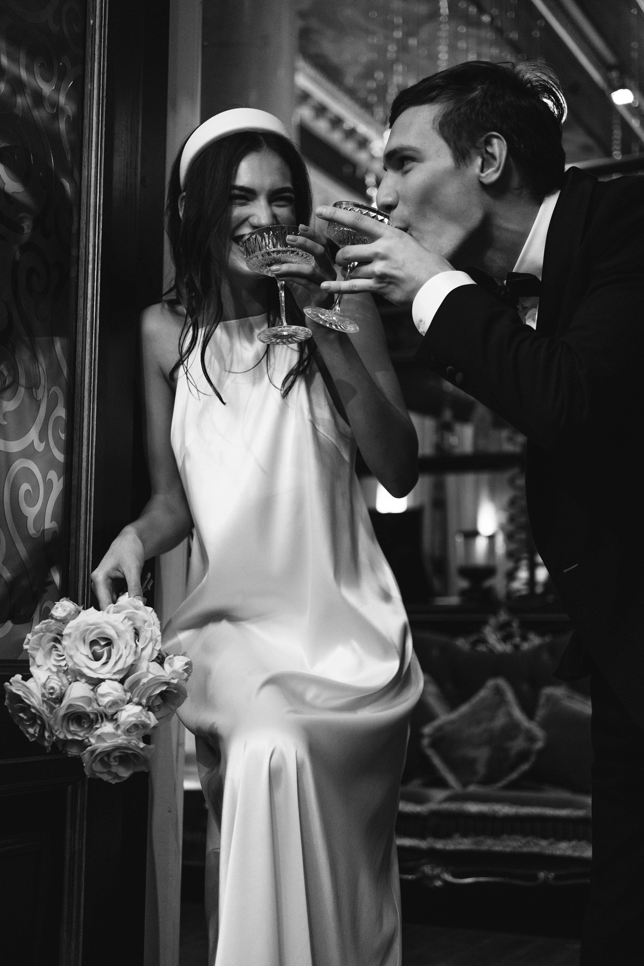 Bride in lace corset gown standing beside a horse in black and white