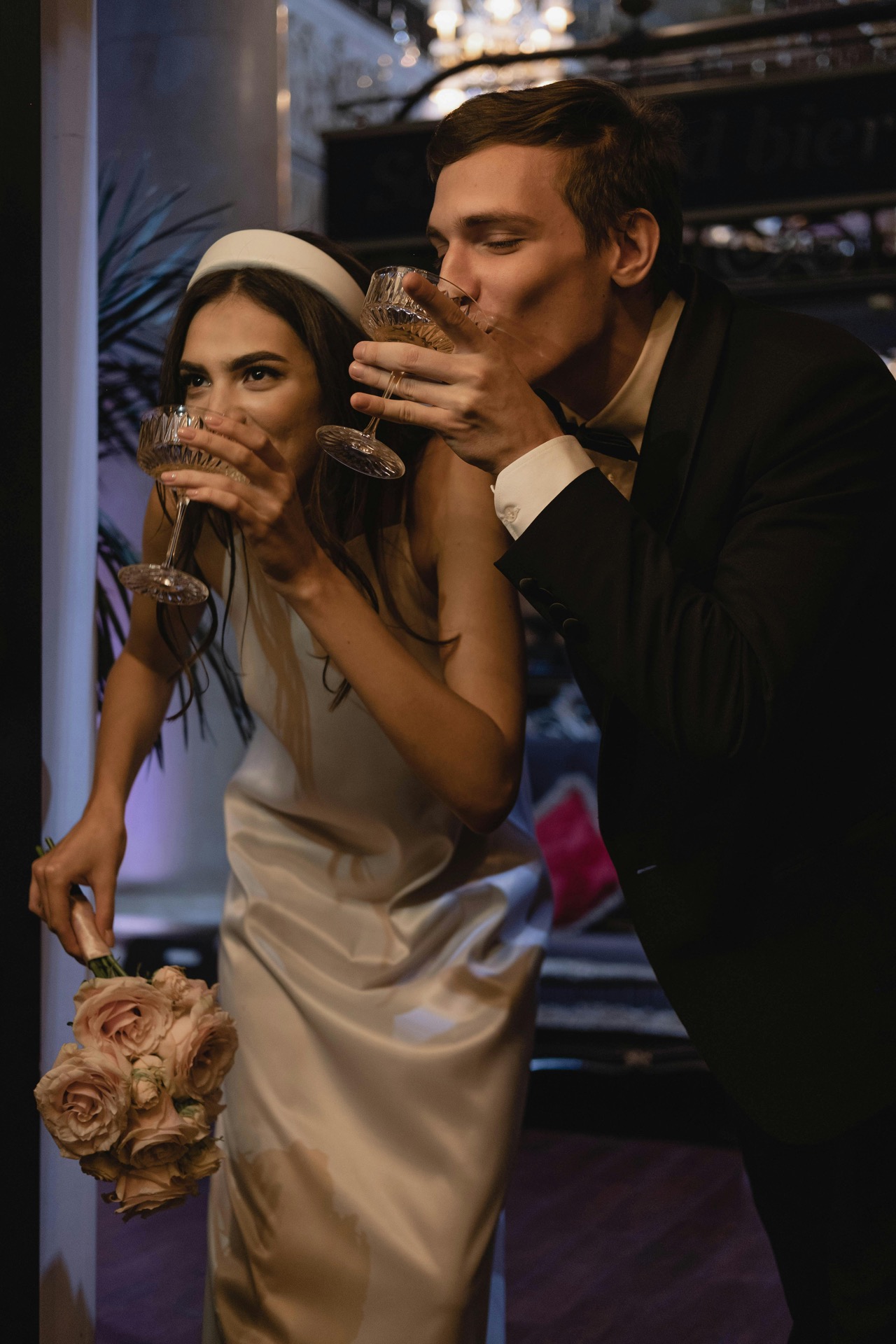 Bride in beaded sweetheart gown leaning against a white column